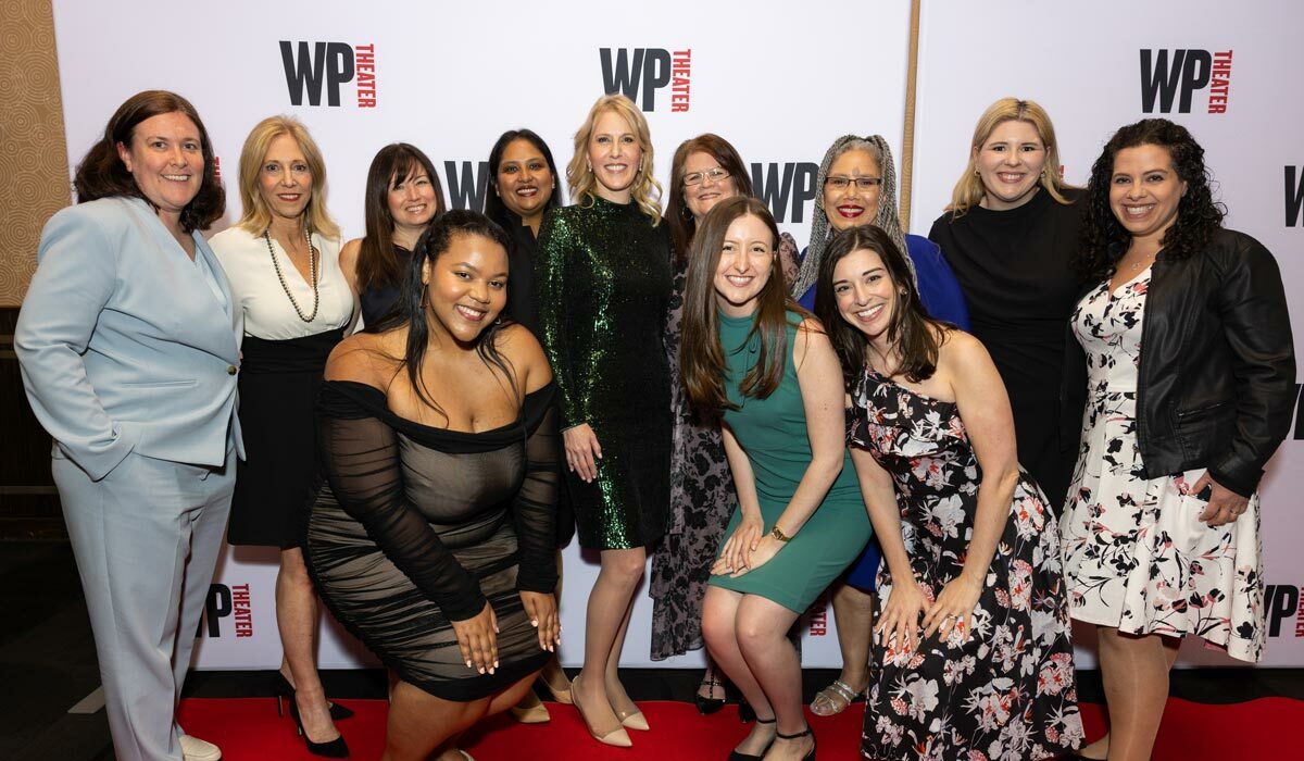 Group of JGO employees posing on red carpet